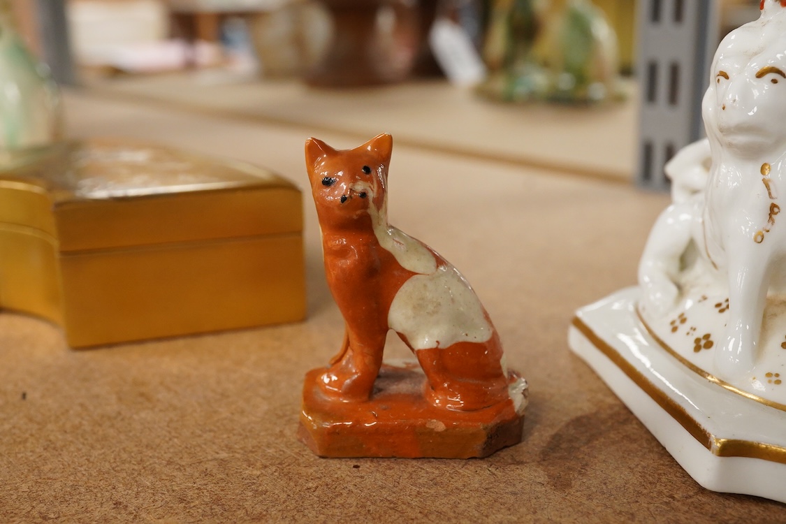 A Staffordshire lion with crown, c.1830-50 and a Staffordshire slipware cat, largest 8.5cm high (2)